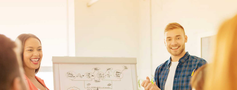 Gründung Zwei junge Menschen halten Präsentation vor Flipchart