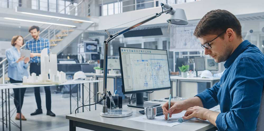 Technologieangebote Mann arbeitet an einem Bildschirm in einer Prototypenwerkstatt